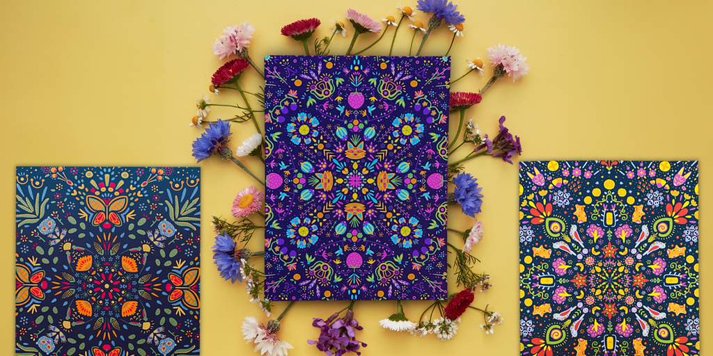 Showcase image of the "Tierra" greeting card collection featuring the "Tierra Verde", "Tierra Fruta", and "Tierra Vida" cards on a golden background with delicate flowers around the center card.