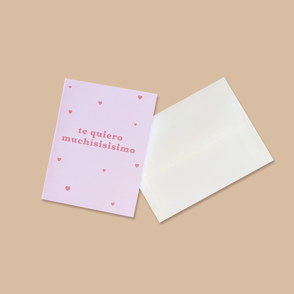 "Te Quiero Muchisisisimo" greeting card next to creme colored envelope.